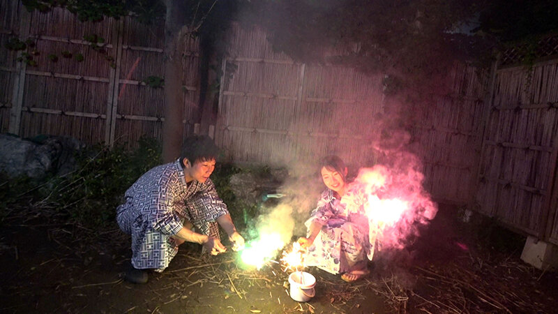 夜中に彼氏の庭で花火を楽しむカップル